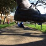 Student artwork of a foot stamping on another person