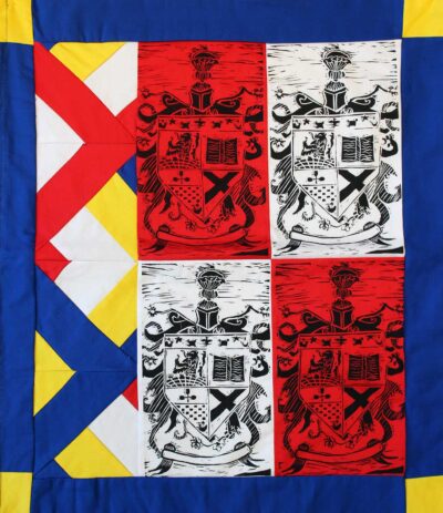Lino cut print on patchwork fabric by Charlotte Fortey, Year 8, St Catherine’s School Student artwork of a coat of arms