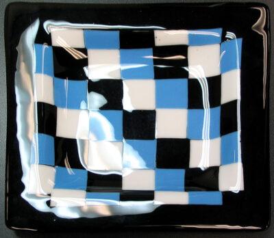 Student artwork of a glass plate in blue, black and white