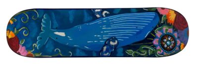 Student artwork of a whale painted on a skateboard deck