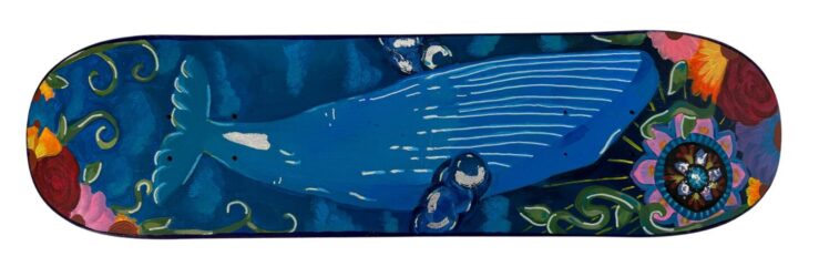 Student artwork of a whale painted on a skateboard deck