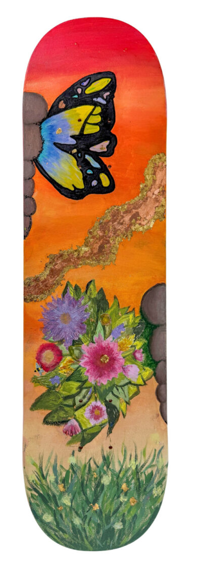 Student artwork of a butterfly and flowers painted on a skateboard deck