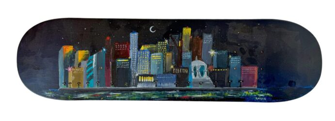 Student artwork of a cityscape painted on a skateboard deck